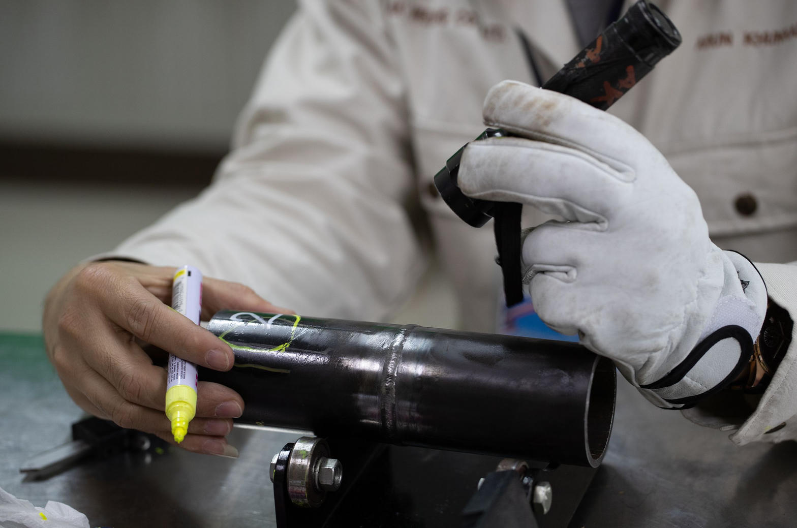 Visual inspector examining weld with flashlight
